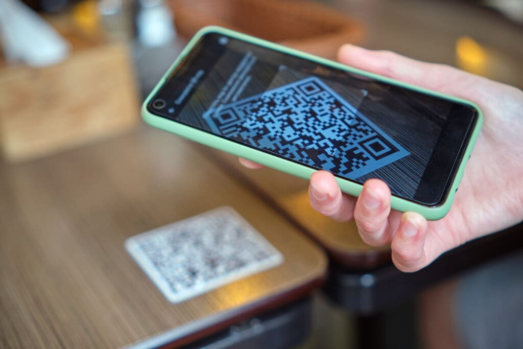 Closeup of guest ordering meal in restaurant while scanning qr code with mobile phone.